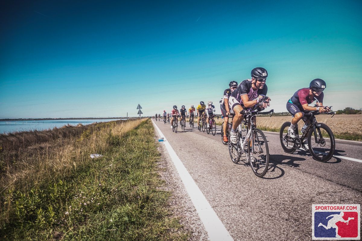 A group of people riding bikes on a road next to a body of water

Description automatically generated with medium confidence