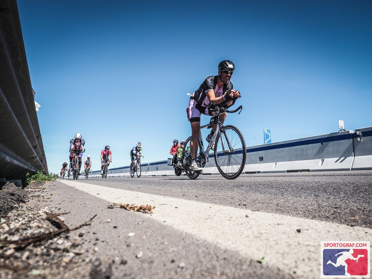 A person riding a bike on a road with other people in the background

Description automatically generated with low confidence